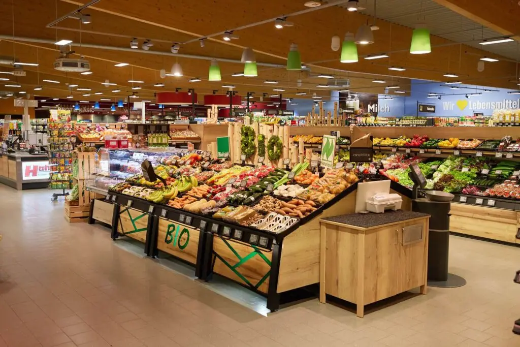 Bio-Obst- und Gem&uuml;seabteilung im Supermarkt, frische Fr&uuml;chte und Gem&uuml;se, Kassenbereich im Hintergrund