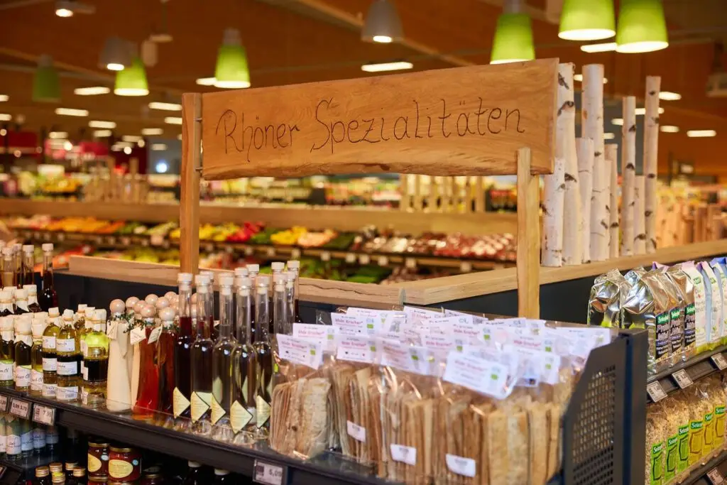 Regal mit Rh&ouml;ner Spezialit&auml;ten: regionale Feinkost, &Ouml;l- und Lik&ouml;rflaschen sowie verpacktes Kn&auml;ckebrot im Supermarkt